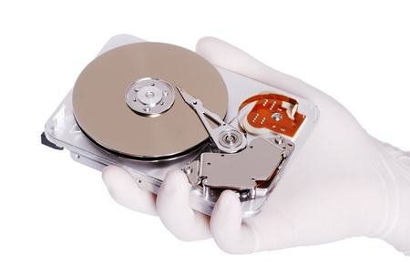 Computer hard disk holds a white gloved handの写真素材