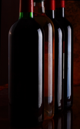 Red and white wine bottles in a rowの写真素材