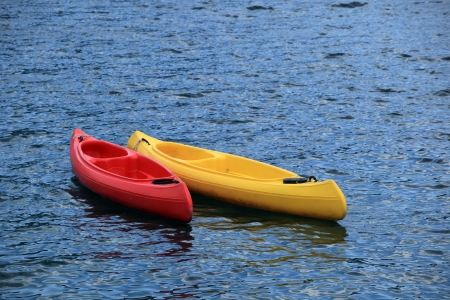 Two fiberglass kayak boat floating on waterの写真素材