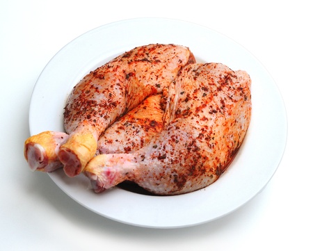 Spiced uncooked chicken legs in white plateの写真素材