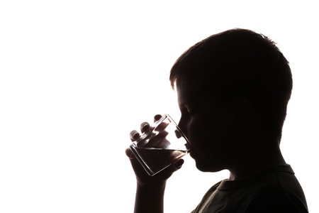 Child drinking glass of water, silhouette imageの写真素材