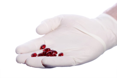 Man s palm holds red pills gloved hand Isolated on white
