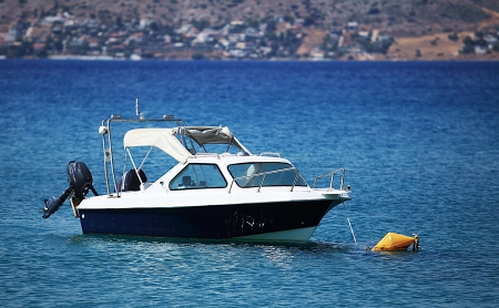 Small motorboat is anchored on the sea