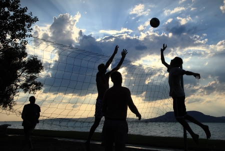 Group of young people playing volleyball on the beachの写真素材