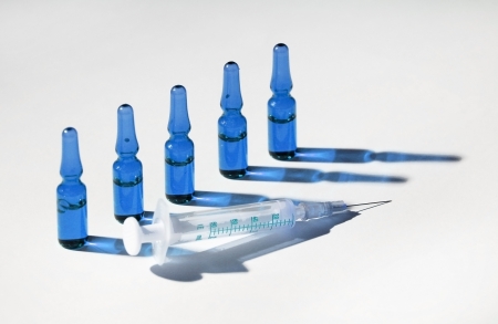 Five medical phials with injection are standing in queueの写真素材
