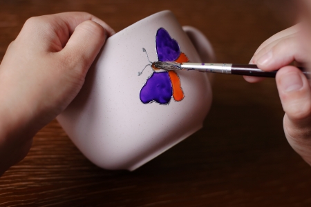 Artist paint colorful butterfly on cupの写真素材
