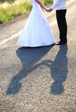 Bride and groom holding hands on wedding dayの写真素材