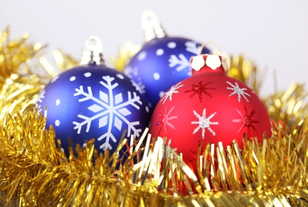 Christmas arrangement with three baubles surrounded with gold ribbonの写真素材