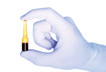 Hand and medical phial on white backgroundの写真素材
