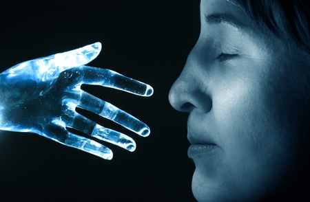 Artificial robot hand touches the nose of a womanの写真素材