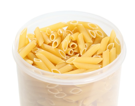 Uncooked penne pasta in plastic holderの写真素材