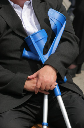 Man sitting with hand crutches
