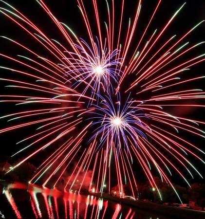 Beautiful red fireworks over waterの写真素材
