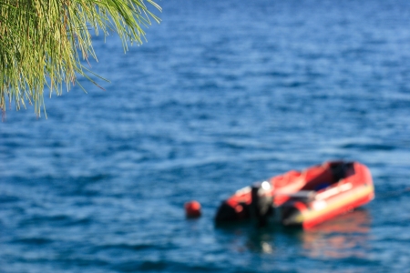 Inflatable red motorboat float on waterの写真素材