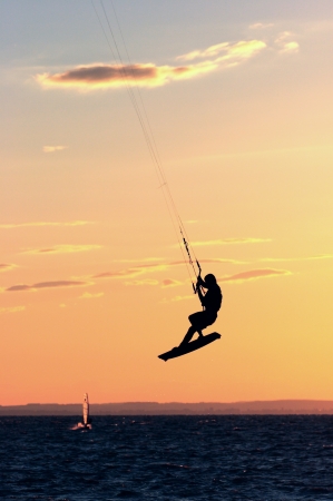 Kitesurfer fly in the air at colorful sundownの写真素材