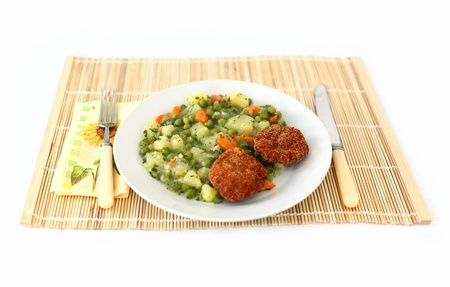 Vegetable dish with fork and knife and wooden tablecloth full isolated pictureの写真素材