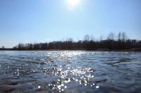 Water surface flowing river blue sunny skyの写真素材