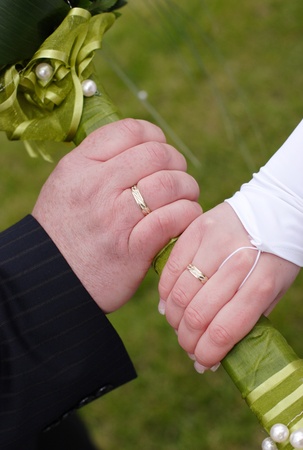Couple with gold ring hold bunch of flowerの写真素材