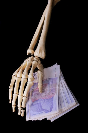 Dead bone hand cover money notesの写真素材