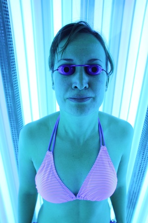 Young woman tanning in solariumの写真素材