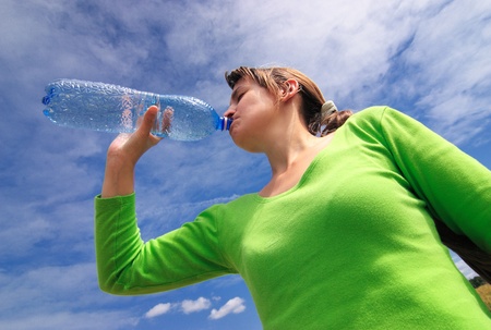 Woman drinking bottled water outsideの写真素材