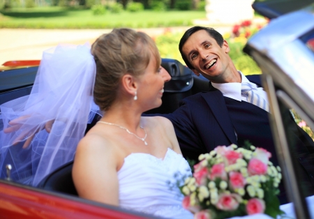 Young wedding couple sitting in cabriolet carの写真素材