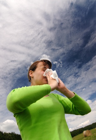 Young woman outdoor has allergy and blowing her noseの写真素材