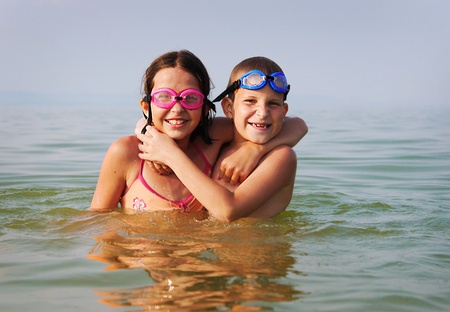 Happy brother and sister embrace each other in the waterの写真素材