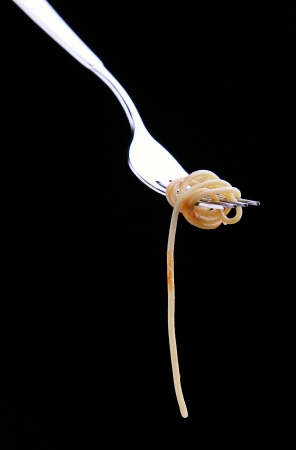Spaghetti on a fork with on black backgroundの写真素材