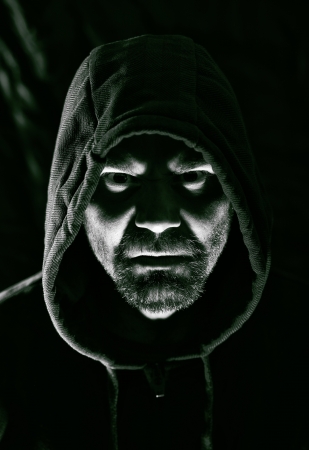 Scary evil man with hood in darknessの写真素材