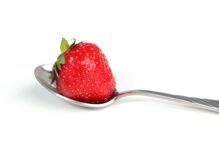 Strawberry on a spoon close up isolated on whiteの写真素材