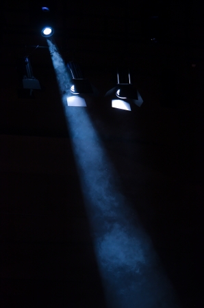 Floodlight goes trough smoke on dark backgroundの写真素材