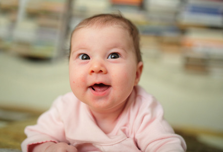 Cute smiling baby lying on bed