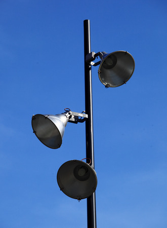 Three lamp on lamppost against blue skyの写真素材