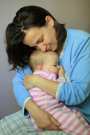 Young woman hug her lovely babyの写真素材