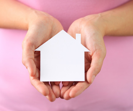 Hands of woman holding paper houseの写真素材