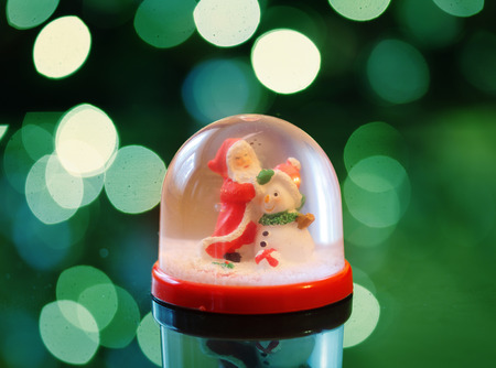 Snowing dome with green absract background at chirtmasの写真素材
