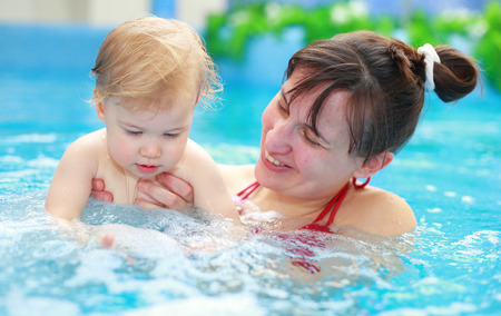 Lovely mother with her child in swimmingpoolの写真素材