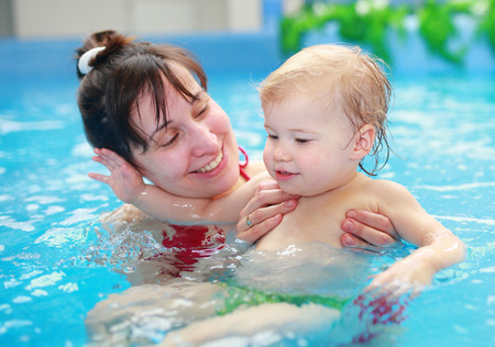 Lovely mother with her child in swimmingpoolの写真素材