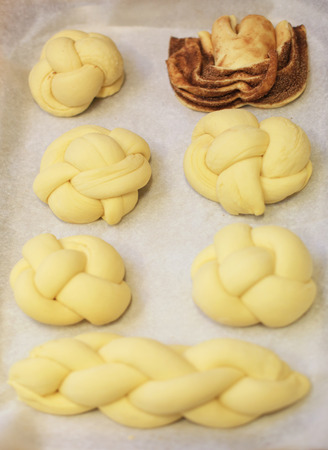 Various raw and baked brioches on plateの写真素材