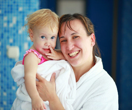 Mother with her lovely child in bathrobeの写真素材