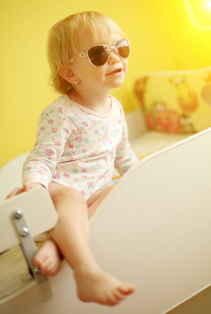 Young cute child wearing sunglasses indoorの写真素材