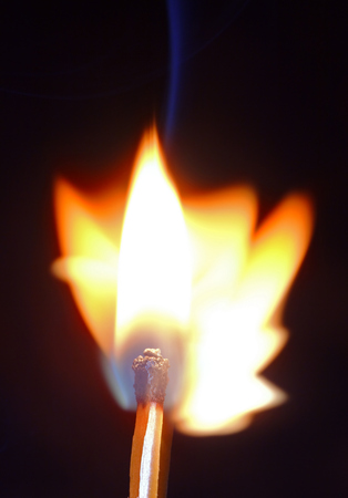 Colorful flame with wooden matchstick, isolated on black, vertical frameの写真素材