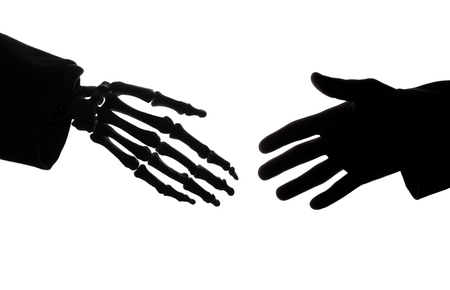 Skeleton hand and hand of businessman handshakeの写真素材