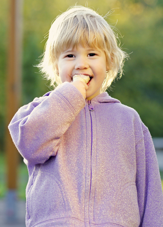 Beauty baby eat ice-cream outdoor in parkの写真素材