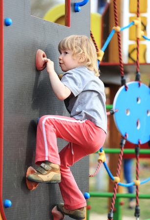 Child on climbing-wall in playgroundの写真素材
