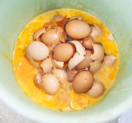 Heap of broken eggs in bowl
