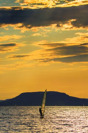 Wind surfing on Lake Balaton at sunset in summerの写真素材