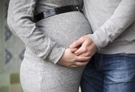 Pregnant woman she and her husband touch bellyの写真素材