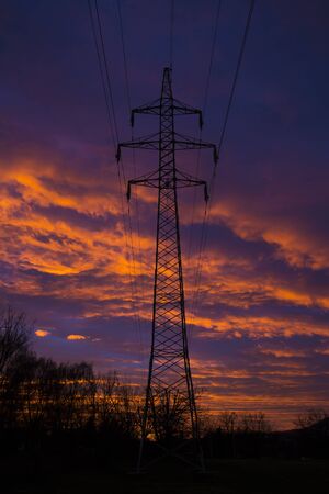 Electric tower at sunset with colorful and dramatic skyの写真素材
